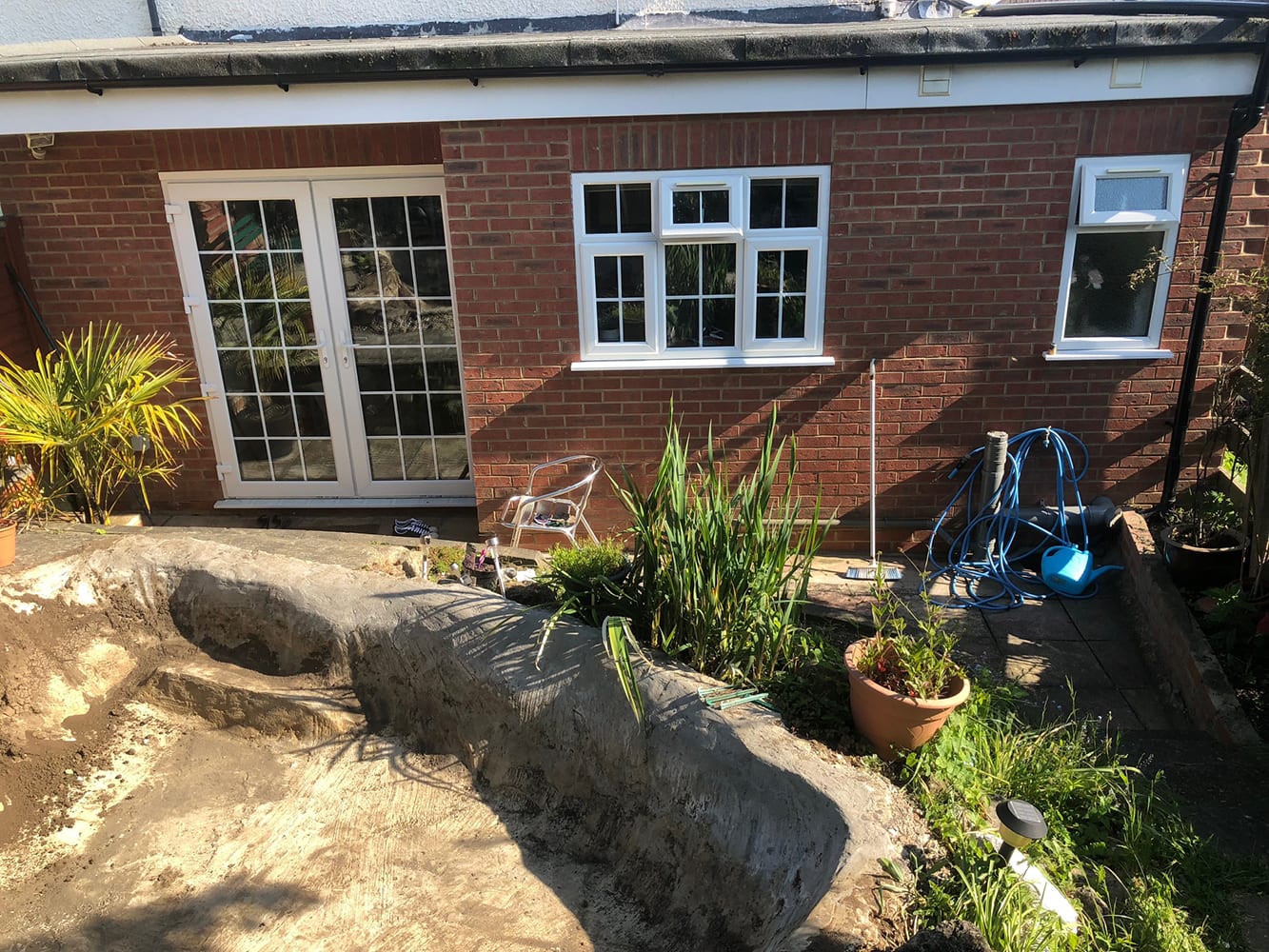 Brick rear extension with French doors opening onto a landscaped garden
