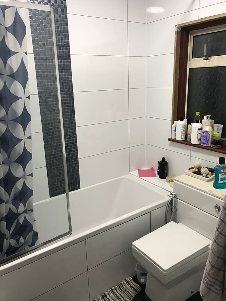 Family bathroom with patterned feature wall and bath