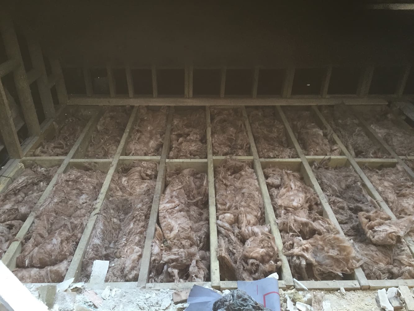New floor joists with insulation laid between them in the loft