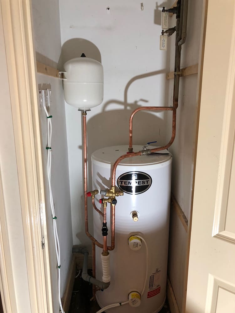 Hot water cylinder with copper manifold pipework