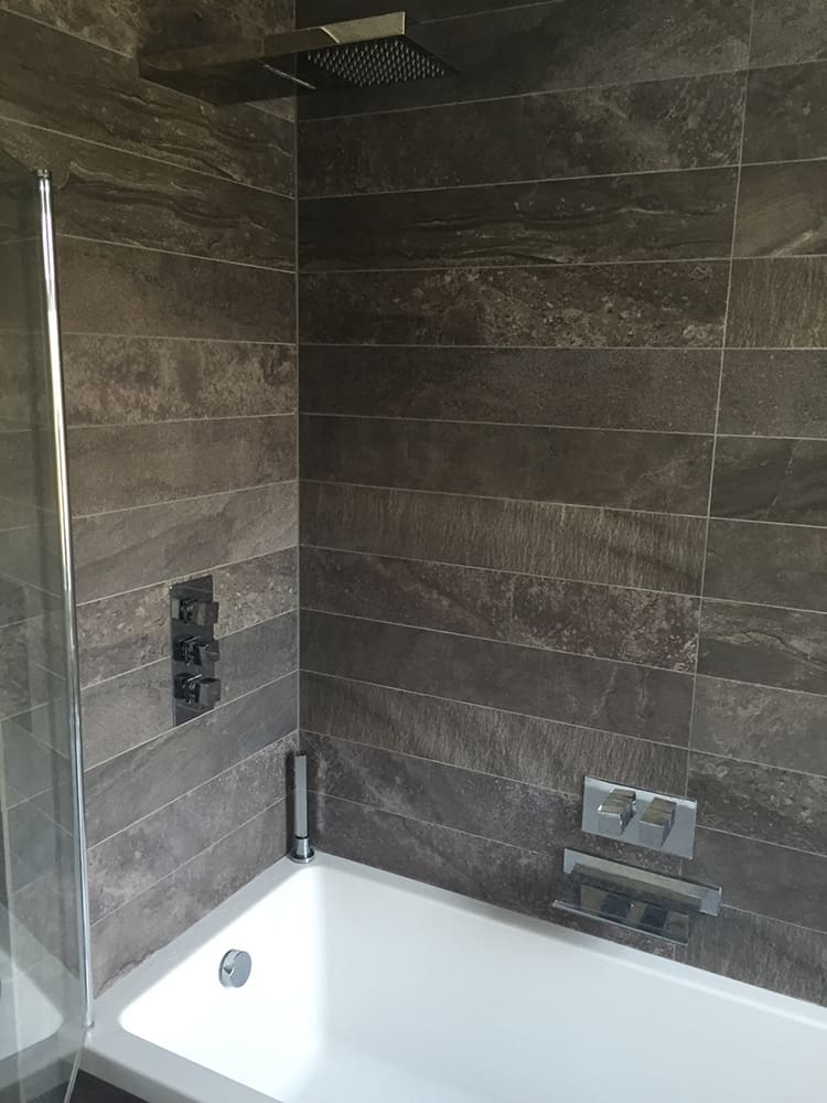 Grey large-format tiled shower with concealed mixer