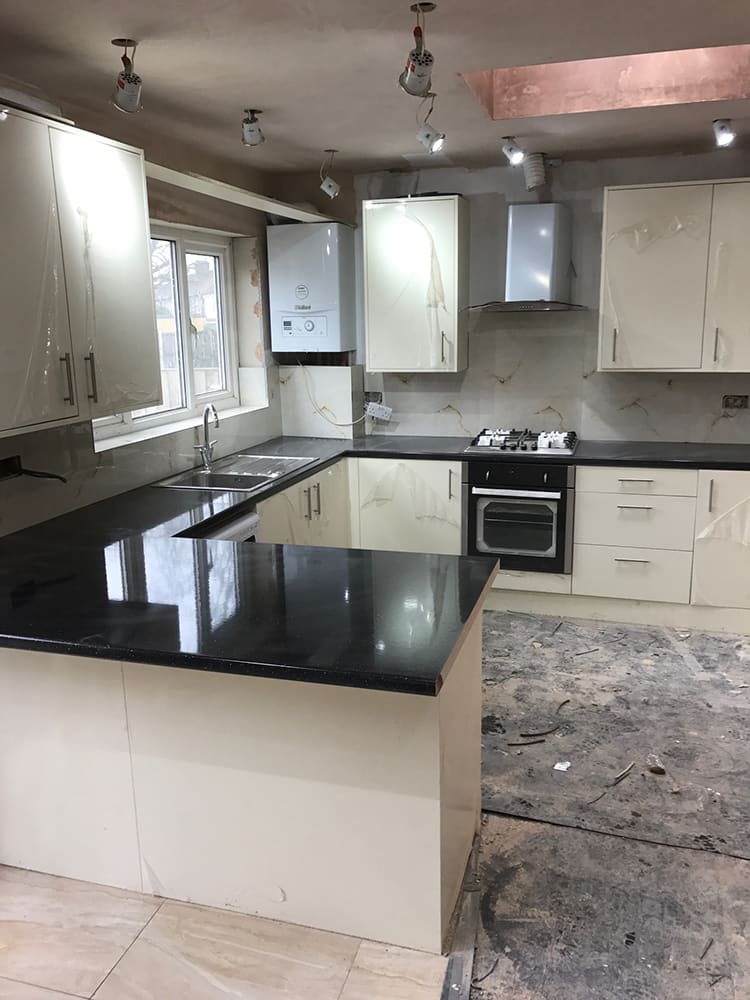 Cream kitchen with black granite worktops and gas hob