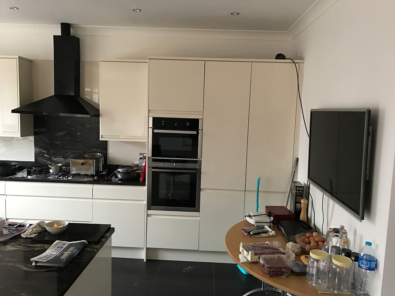 White handleless kitchen with black hob and wall units
