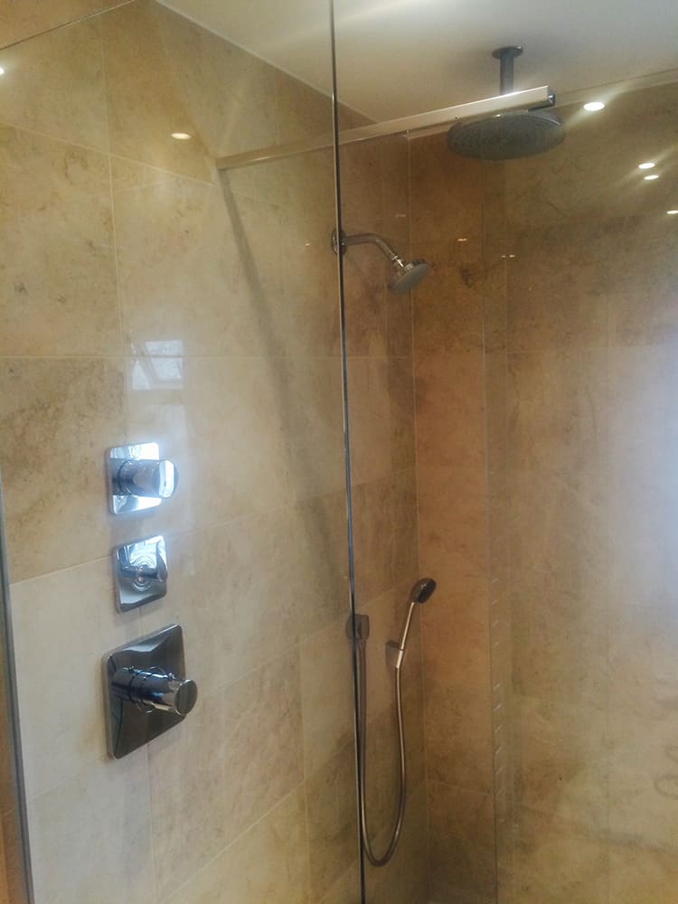 Glass shower screen against travertine tiling