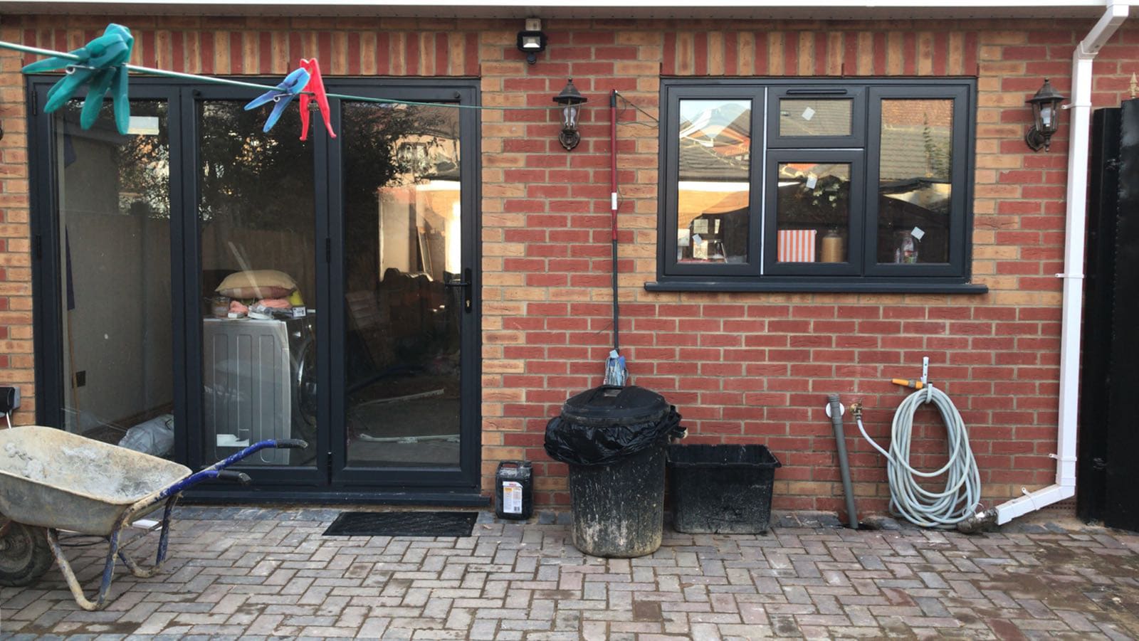 Brick rear extension with dark-framed glazing and patio