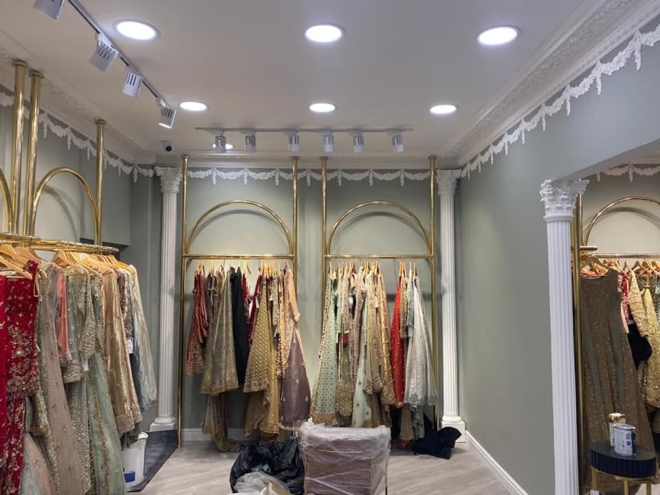 Finished boutique interior with garments on gold display arches