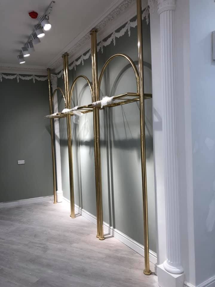 Gold display arches being assembled against the wall