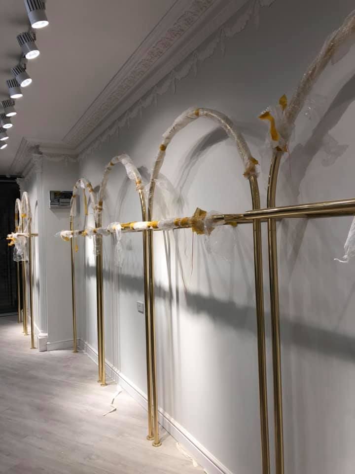 Gold display rails fixed along the boutique wall