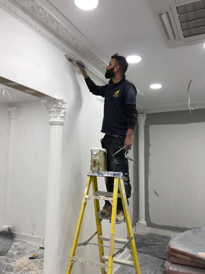 Decorator finishing ornate plasterwork by hand