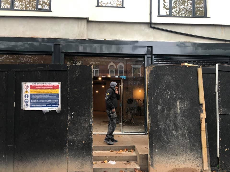 New shopfront glazing being installed behind protection boards