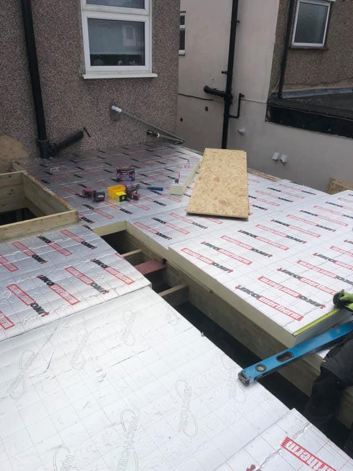 Insulation boards laid over the flat roof deck before boarding