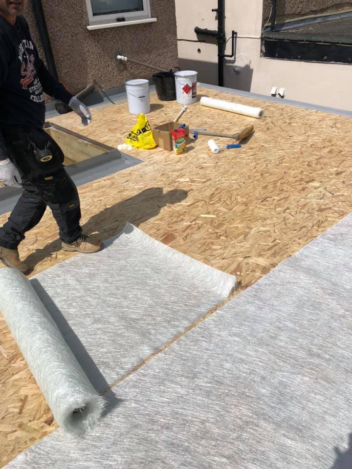 GRP matting being rolled onto the flat roof deck