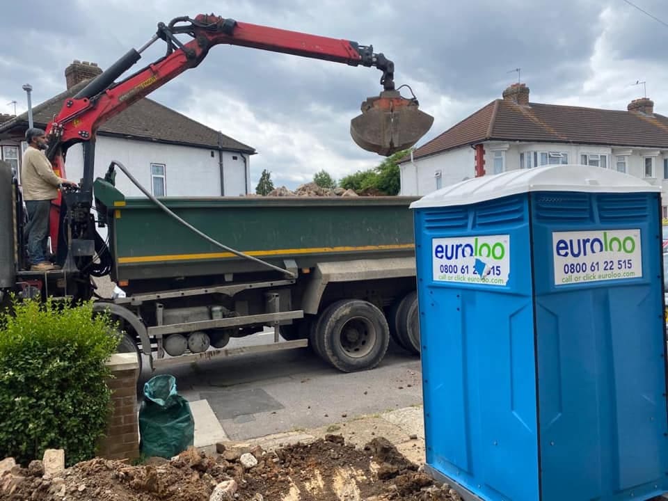 Grab lorry removing excavation spoil from the front of the house
