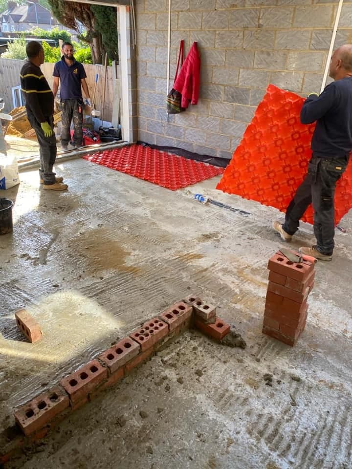 Red underfloor heating pipe clipped in circuits over insulation