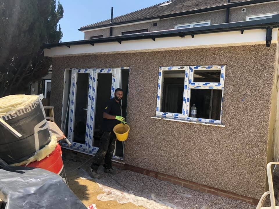 Operatives installing windows in the rendered rear extension