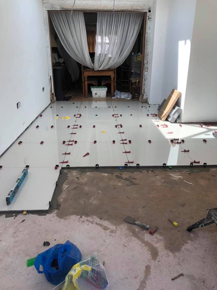 Large-format floor tiles being laid with levelling clips