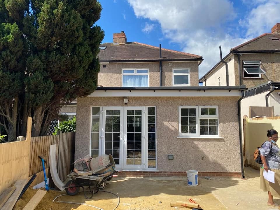 Completed rendered rear extension with French doors and new patio