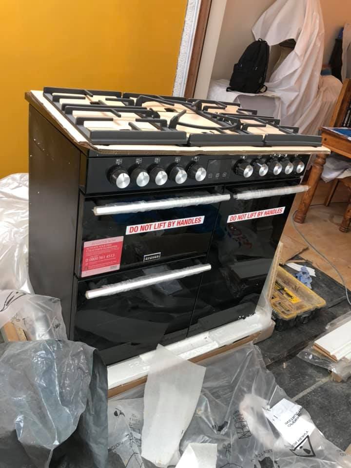 Black range cooker positioned during kitchen installation