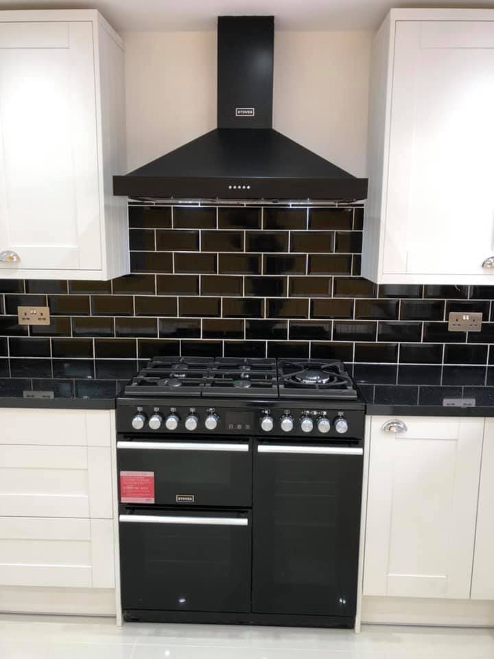 Black chimney hood over range cooker in the finished kitchen
