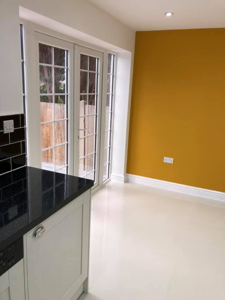 Black granite worktop against the ochre wall in the finished space