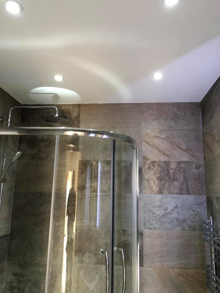 Quadrant shower enclosure in the stone-tiled bathroom