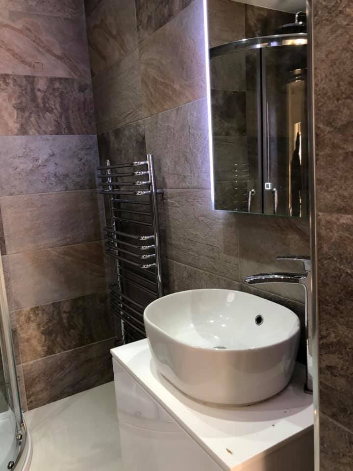 Countertop basin with mirror cabinet in the tiled bathroom