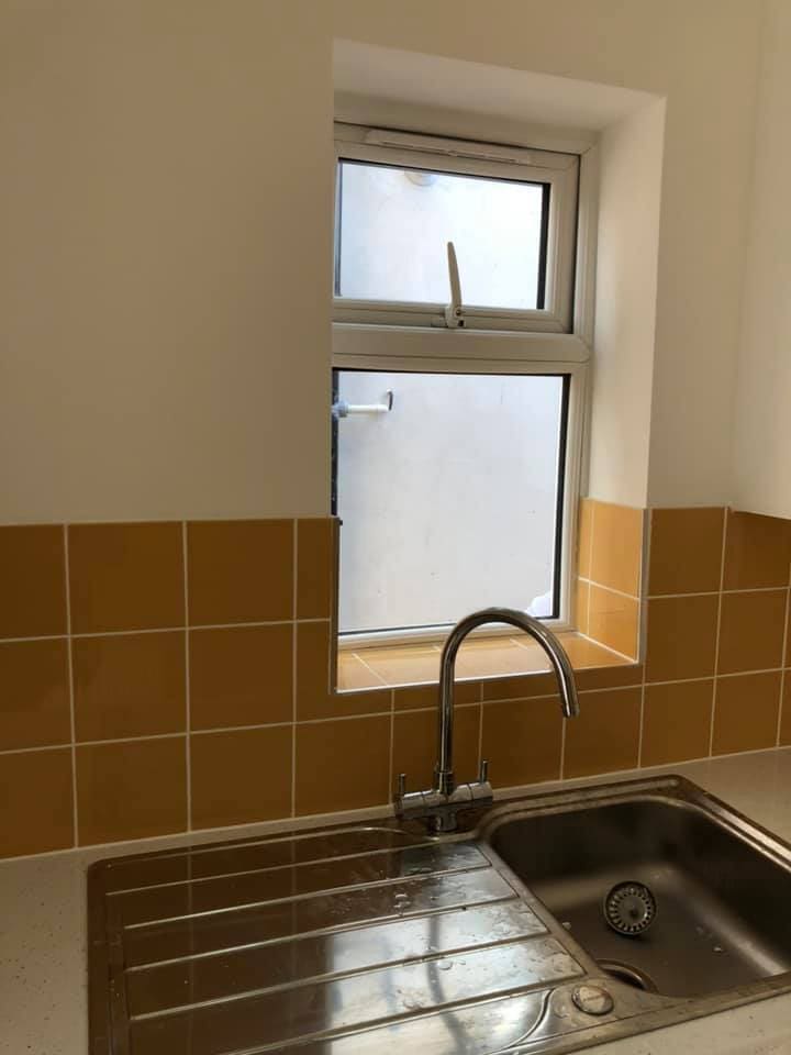 New worktop and sink against ochre tiled walls