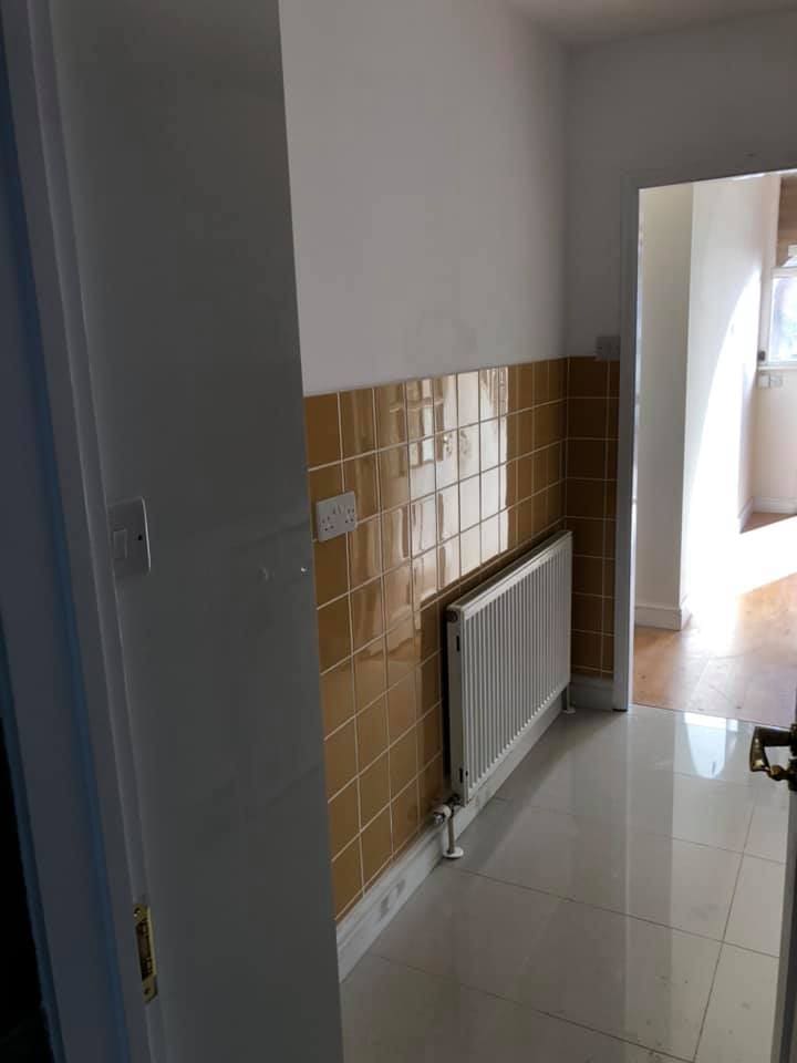 Completed compact kitchen with radiator and tiled walls